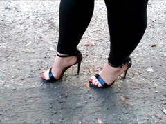 Wife walk on puddles in high heels sandals